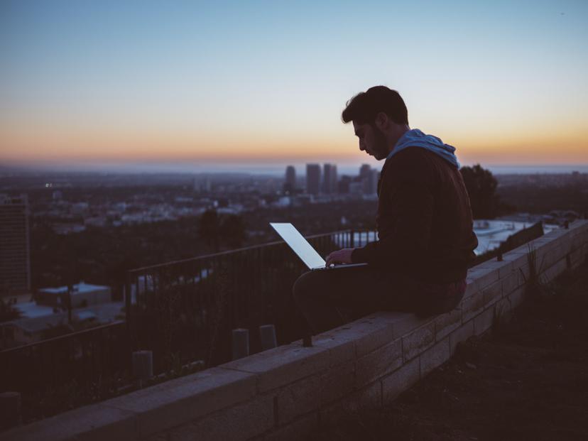man on laptop overlooking cityscape