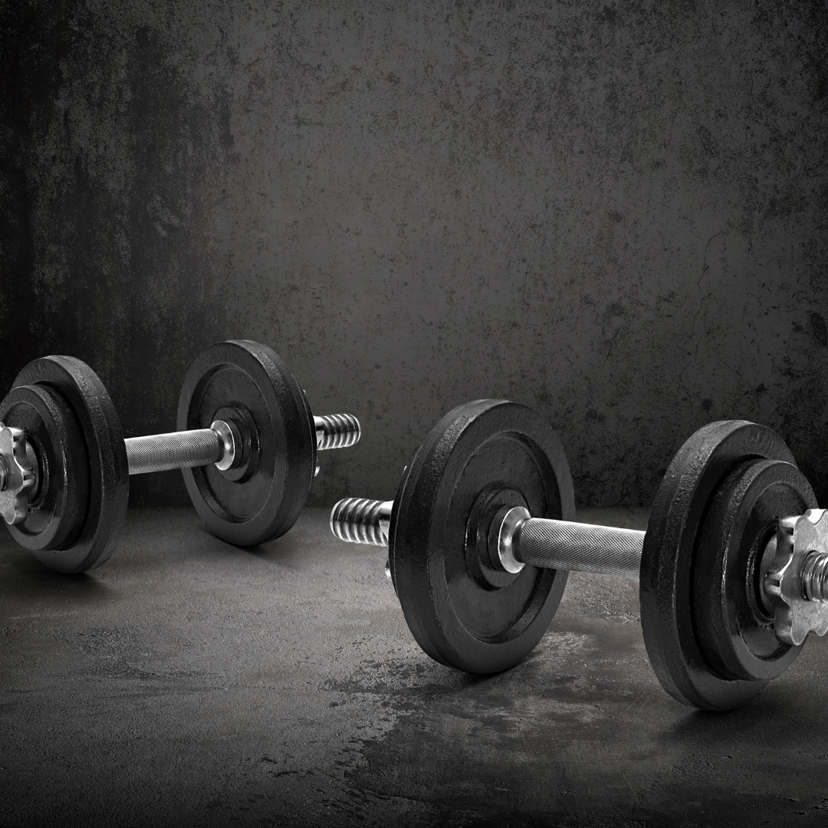An image of dumbells on a concrete floor