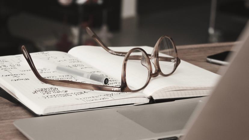A pair of glasses sitting on a notebook