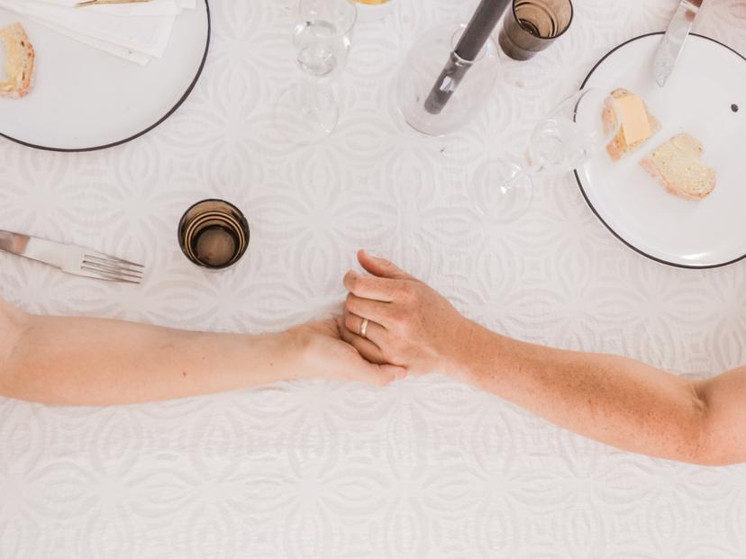 A couple holding hands on a dinner table
