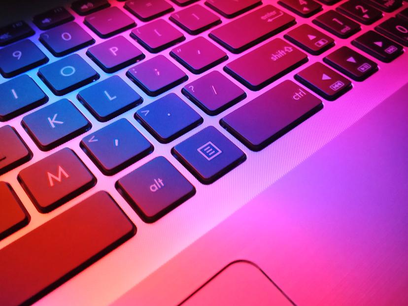 Laptop keyboard in a multi coloured glow.