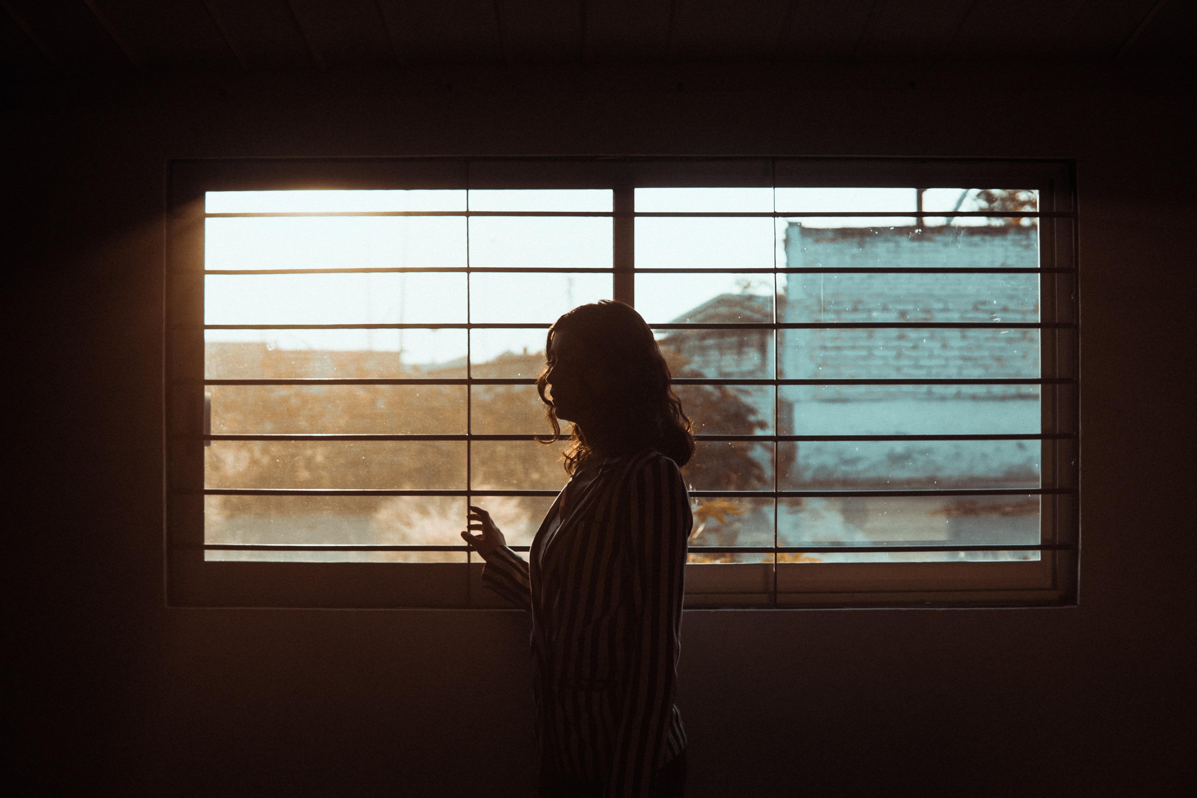 Woman standing in front of blinds