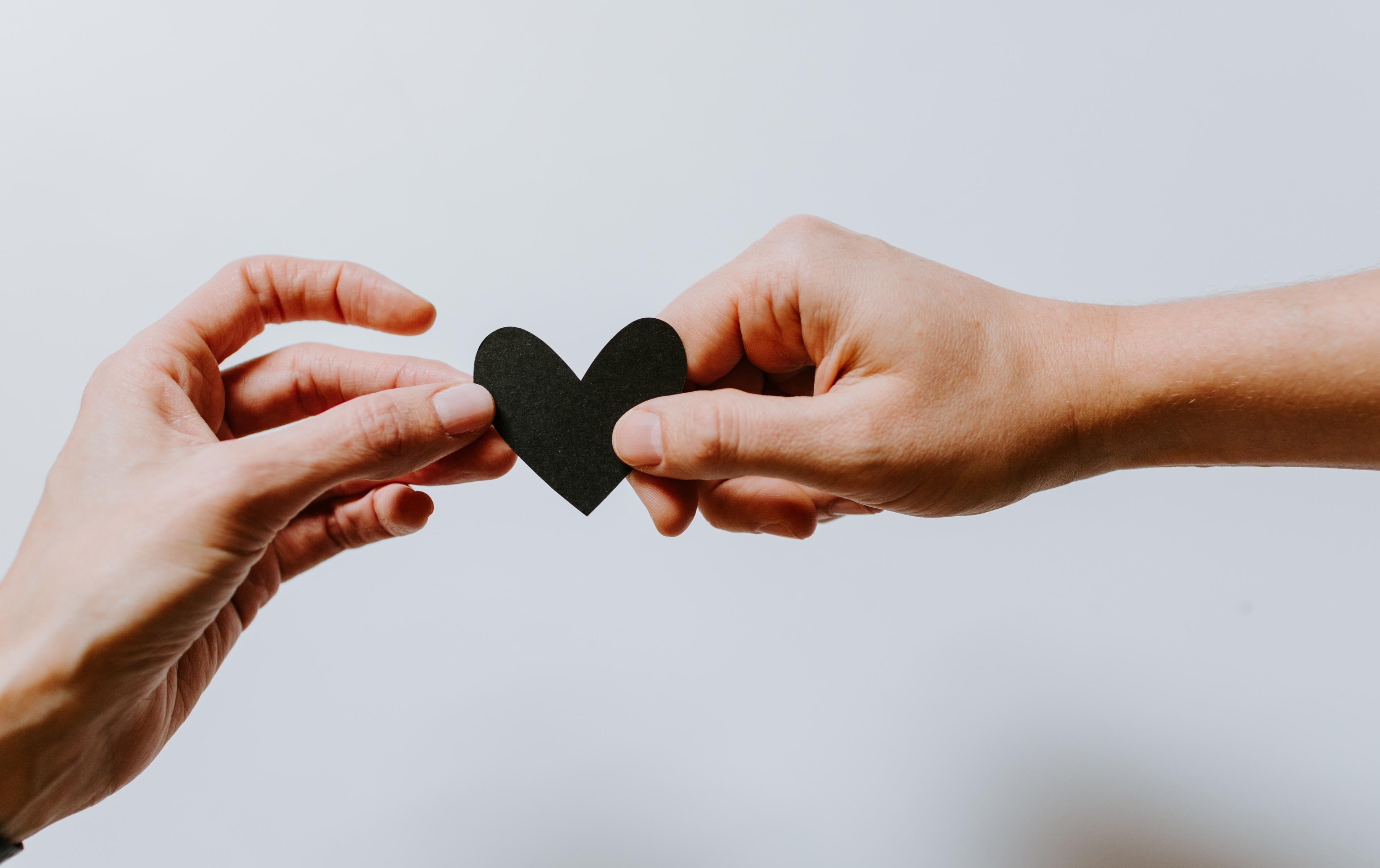 Two people holding a paper heart