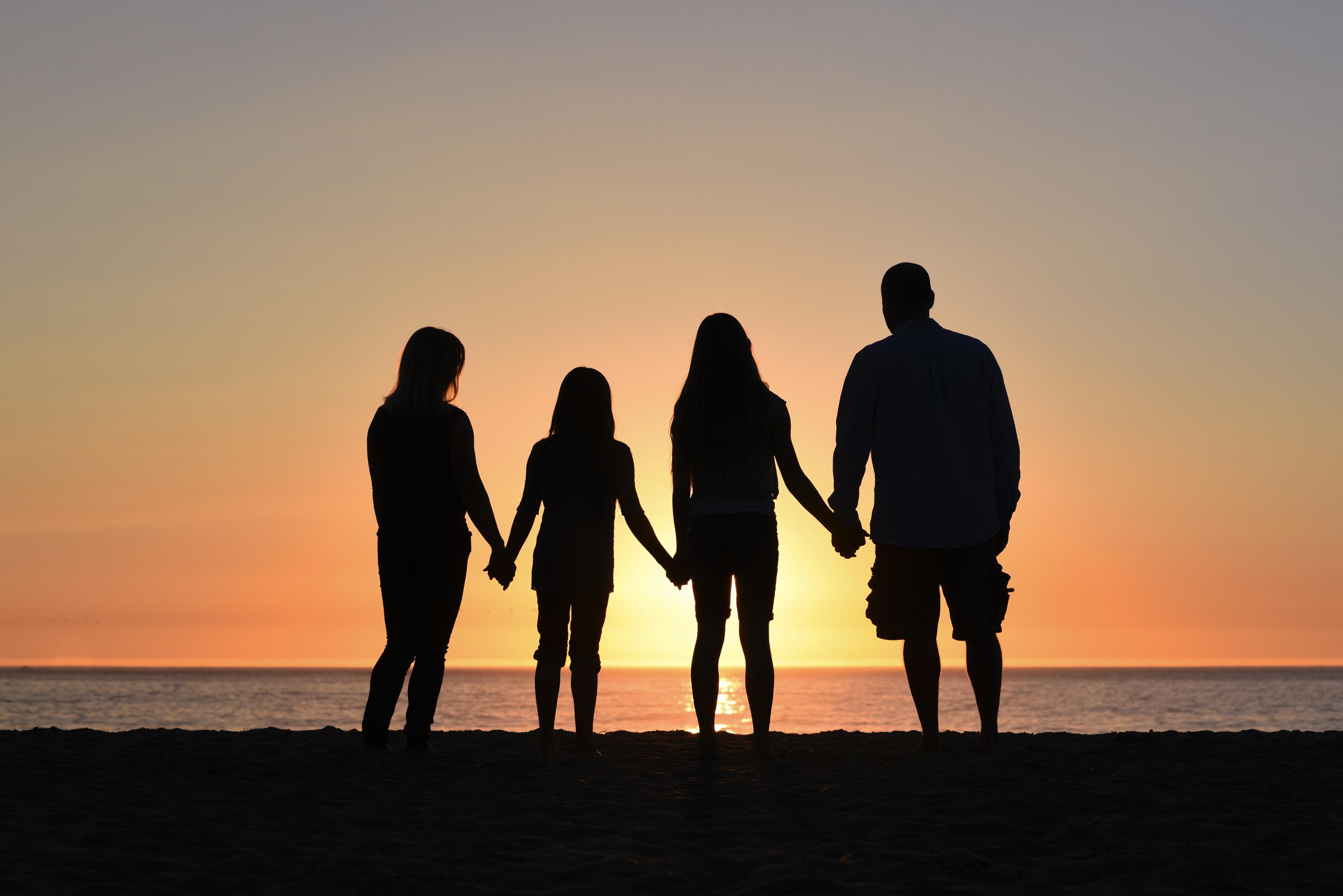 A family outlined against the setting sun